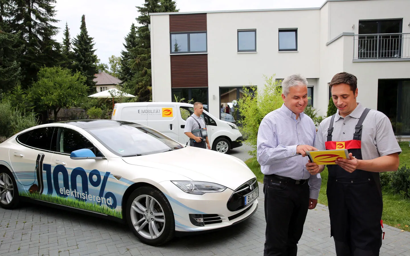 E-Mobilität - Mitarbeiter mit Kunden vor Elektrofahrzeugen 100% elektrisch &middot; Palzer Elektro